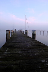 Fototapeta premium Sonnenaufgang im Nebel über dem Hafen Prerow am Prerowstrom, Halbinsel Fischland-Darss-Zingst, Mecklenburg-Vorpommern, Deutschland