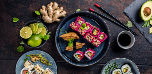 Delicious rolls, sushi and maki on a dark wooden Board with chopsticks. On black rustic background