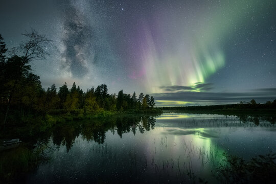 The Milky Way and Auroras above a still lake with reflections © Timo Oksanen