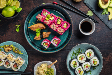 Delicious rolls, sushi and maki on a dark wooden Board with chopsticks. On black rustic background