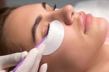 Woman with long lashes in a beauty salon. Eyelash extension procedure.