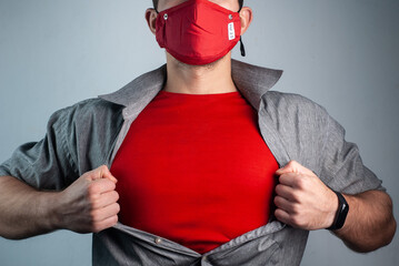 Super man in red medical mask rips shirt on chest