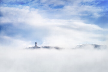 Fototapeta na wymiar The Tisnov lookout tower, also known as Klucanina, stands on the hill of the same name, shrouded in a morning inversion.