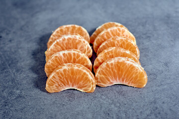 High angle shot of tangerine pieces on a rough surface