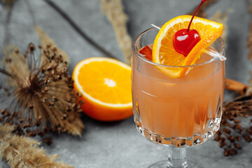Mulled wine in glass glasses with apples orange and cinnamon. Hot Christmas drink on a grey...