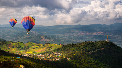 Top view Beautiful Scenery Village With Hot Air Balloons and Wat Pa Phu Thap Boek "Buddhist Temple" peaceful On Rock Mountain in Phetchabun Province, Thailand.