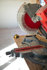 Building contractor worker using hand held circular saw to cut boards on a new home constructiion project sit