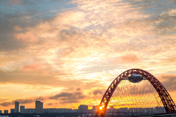 Obraz premium Zhivopisny suspension bridge winter sunset landscape in Moscow, Russia. Red beautiful modern suspension bridge 