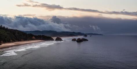 Cannon Beach, Oregon, United States. Beautiful Aerial Panoramic View of the Rocky Pacific Ocean Coast. Dramatic Cloudy Sunrise Sky.