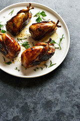 Roasted quails on white plate