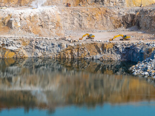 yellow heavy excavators extract granite in a granite quarry