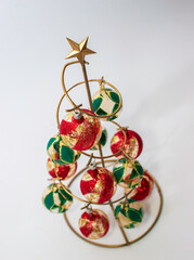 arbol metalico hecho a mano con esferas navideñas de cristal verdes y rojas