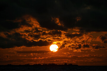 Contrast red sunset and dark clouds
