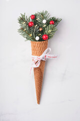 Christmas concept background. Fir branches with Christmas decorations in ice cream cone