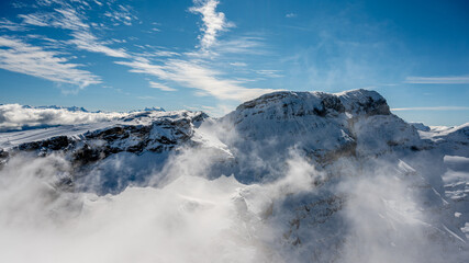 Obraz premium Winter landscape of snow covered mountains with blue sky and clouds on sunny day. Famous Diablerets Glacier in Switzerland.
