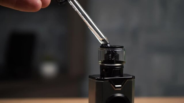 a person fills his vape with a special liquid