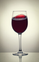 Red wine glass on the bright background