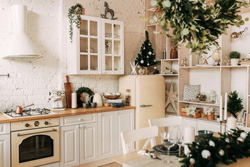 Interior of a light kitchen decorated with Christmas decorations and fir plants in natural materials and colors in a cozy home