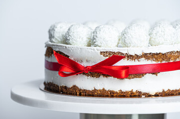 Coconut cake with coconut balls on top, white background
