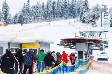 Skiers queuing for a chair-lift