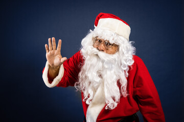 Retrato de papa noel señalando ofertas en traje típico navideño