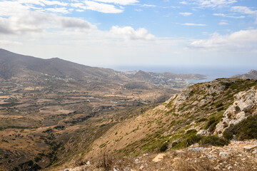 A view of west coast of Ios Island. Chora town and port in the background. Cyclades, Greece