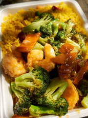 Shrimp with broccoli over fried rice - an iconic Chinese/American takeout dish in a plastic foam container