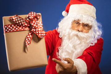Retrato de papa noel mostrando un regalo acercamiento para navidad felices fiestas