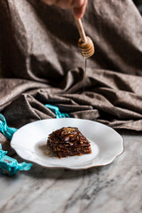 Perfect sweet turkish baklava with pistachio on marble background and wooden honey dipper

