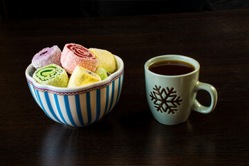 Turkish Delight in a porcelain vase and a cup of coffee on a black background