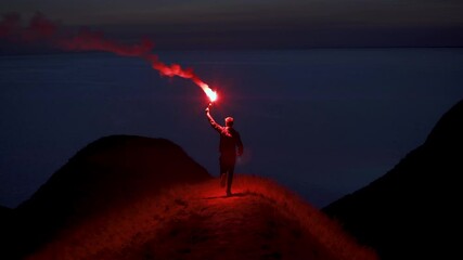 The man runs with a burning fire stick on the mountain