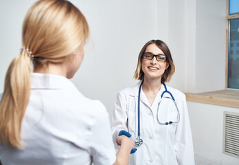 Fototapeta premium Doctor and patient near window in hospital interior 
