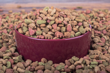 studio lighting. animal feed is scattered on it, there is a bowl in it, a granule is poured.