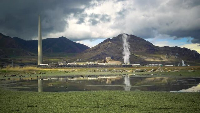Oil refinery and a factory for obtaining silver on the shore of the Great Salt Lake against the backdrop of mountains and clouds. Utah, US