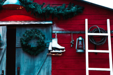 barn of the house decorated for Christmas with light bulbs, wreaths, skates and garlands