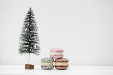 Macaroons or macarons and Christmas tree on a white background. Congratulations to the holidays. Minimalistic concept.