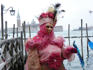 Fototapeta na wymiar Pink costume, gondolas, venetian carnival masks