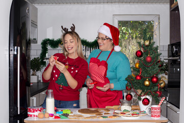 Obraz na płótnie Canvas Women teaching girl to make Christmas cookies