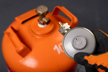 Propane-butane gas cylinder and reducer. Combustible gas used in households.