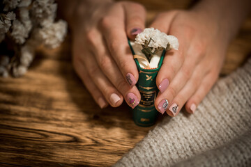 Vintage novel books with bouquet of flowers on old wood background.Mini book