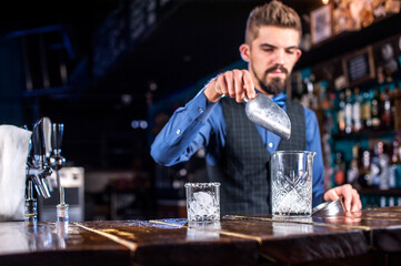 Experienced bartender demonstrates his skills over the counter in the night club