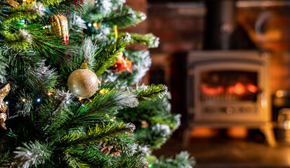 Close up of christmas tree bobbles with blured out fire in background. home living room shallow depth of field