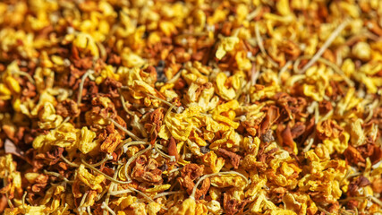 Bright, yellow osmanthus flowers for tea drinking, macro picture with blurred background.