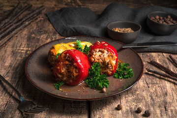 Bell pepper stuffed with minced meat on a wooden brown background. Side view. Concept of culinary backgrounds.