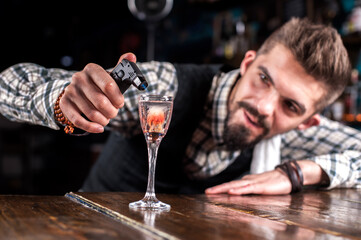 Charismatic bartending decorates colorful concoction in the pub