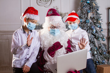 Santa Claus and two boys in N95 Face Mask during coronavirus quarantine in a red cap and with a big...