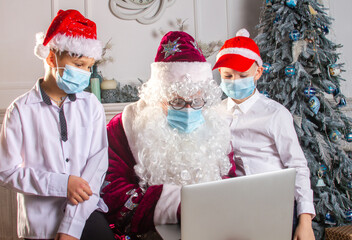 Santa Claus and two boys in N95 Face Mask during coronavirus quarantine in a red cap and with a big...