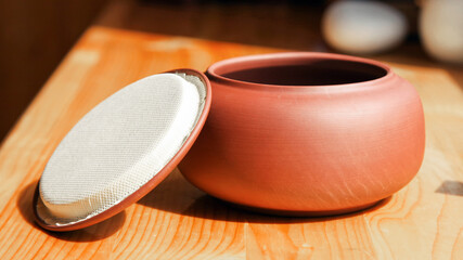 Chinese Tea caddy of red clay with an open lid, close-up image. 