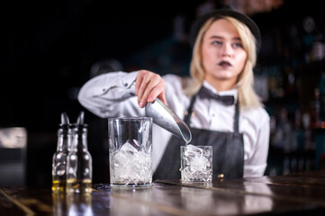 Young woman bartending demonstrates his professional skills in the night club