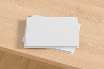 Horizontal or landscape white hardcover book stack mockup on the wooden table.